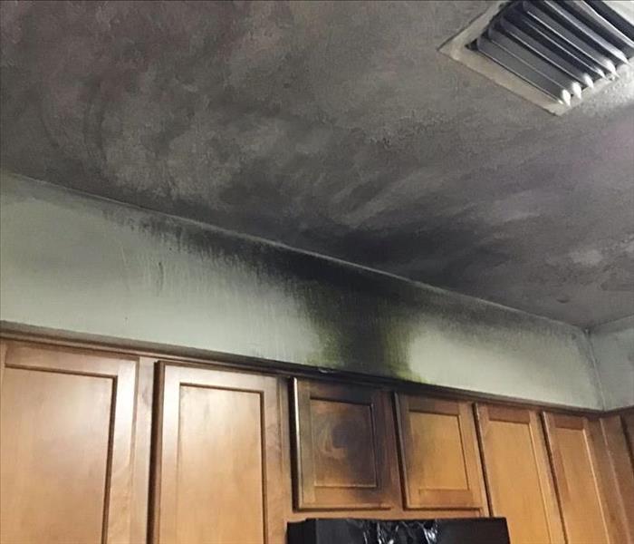 Soot damage on kitchen walls, cabinets, and ceiling