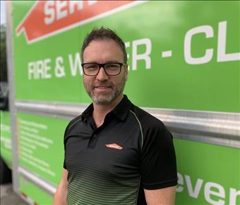 man standing in front of SERVPRO green truck