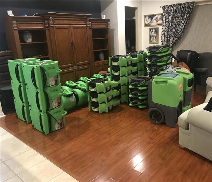 living room stacked with green drying equipment--staging area