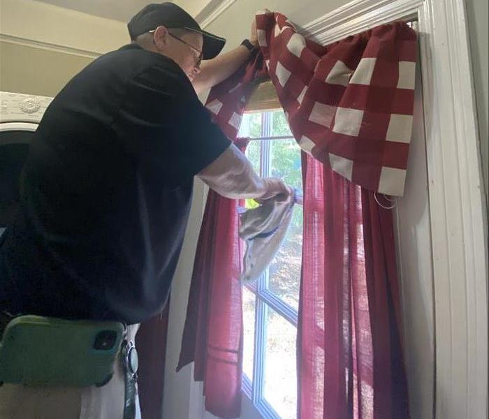 SERVPRO team member performing cleaning services on a window