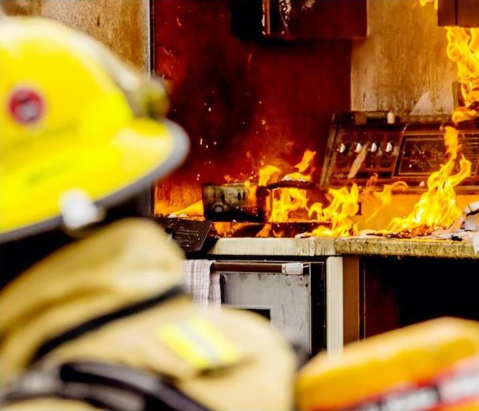 fire fighter in kitchen battling a fire