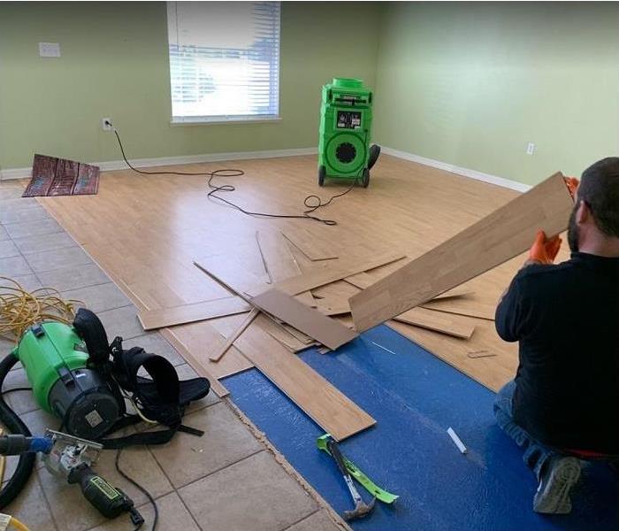 SERVPRO tech ripping out water damaged flooring