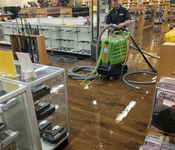 a SERVPRO employee working to help water damage in a commercial space by using a SERVPRO machine