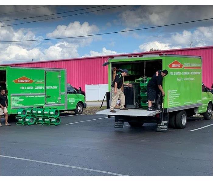 SERVPRO technicians loading V=vehicles in the Green Fleet with restoration equipment