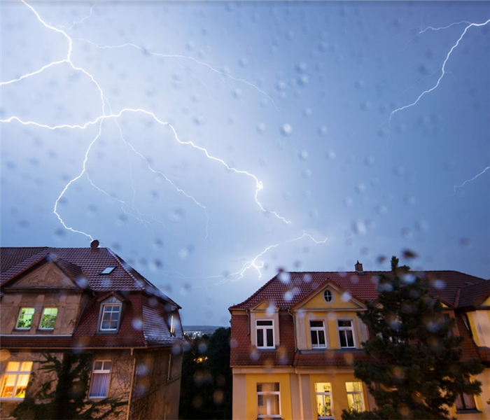 lightning striking above two houses